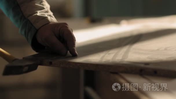 一个男人组装家具用锤子和钉子视频