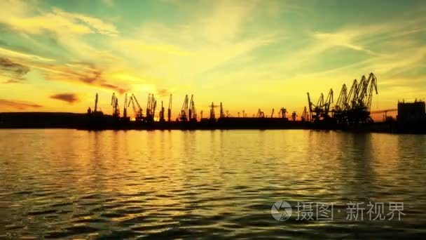 七彩的晚霞，在海港口货物港口起重机与史诗般充满活力的天空