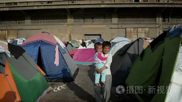 雅典 4 月 12 日︰ 叙利亚男孩与他的双臂从希腊港口 2016 年 4 月 12 日在雅典的叙利亚难民的帐篷营地的小妹妹