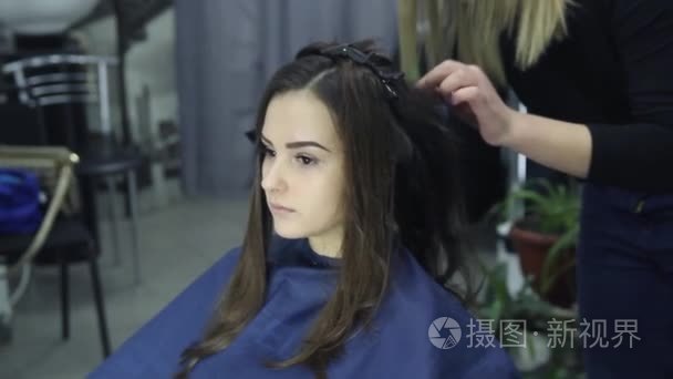 女理发师站和可爱可爱的年轻女子在美容院做发型短视频