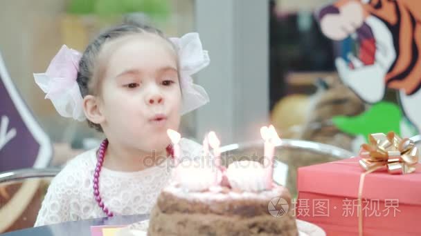 吹蜡烛的生日蛋糕上的小女孩