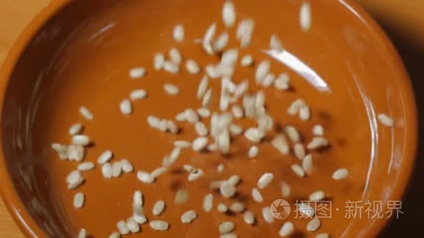 整个水稻谷粒落在棕色陶瓷碗视频