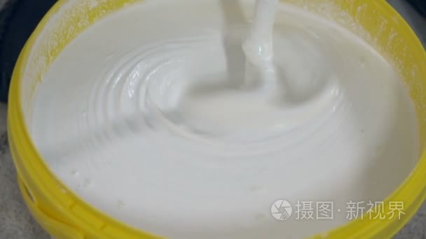 该工作人员搅拌腻子混合物视频