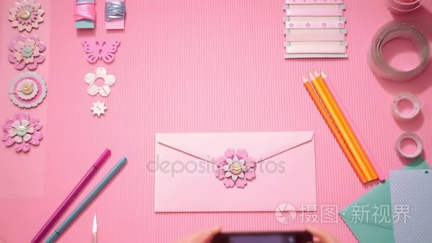 顶视图女孩照片制作的喜庆粉色信封的智能手机