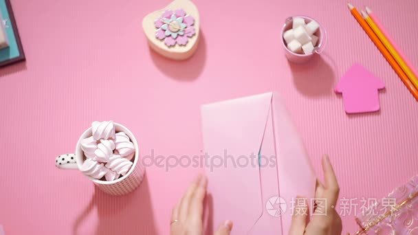 顶视图女孩与节日剪贴簿明信片打开一个粉红色的信封