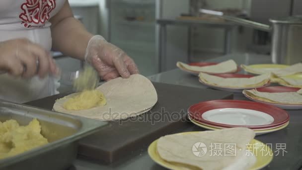 女人在面包中包装土豆泥视频