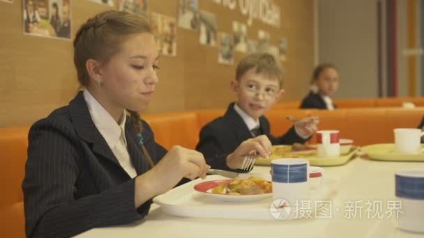 女孩和男孩在食堂里吃晚餐视频