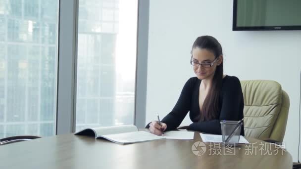 女孩在办公室在桌子上，阅读文档