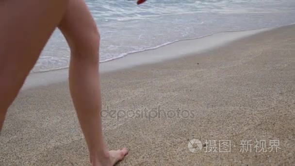 放松的女孩在日落时分的地中海的沙滩上独自行走