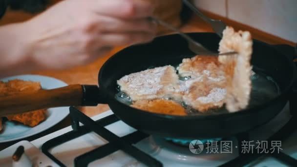 家用厨房一个煎锅煎肉排骨。慢动作