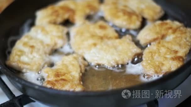 一个煎锅在自家厨房的烹饪肉。慢动作