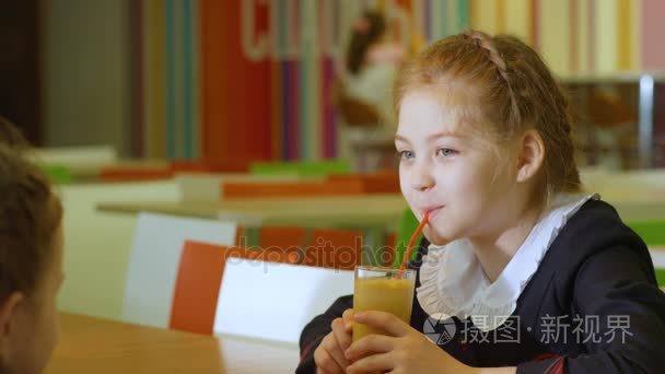 女学生在学校食堂喝果汁