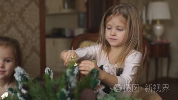 两个小女孩正在做圣诞花环