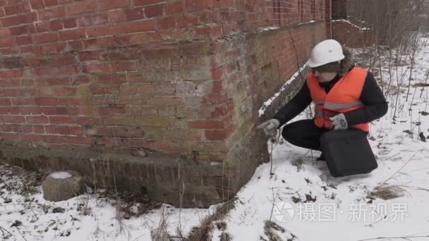 建筑监理员检查在老建筑上的砖视频