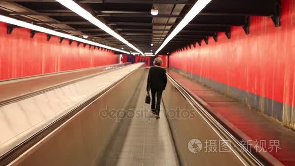 女人走上移动自动人行道在走廊视频