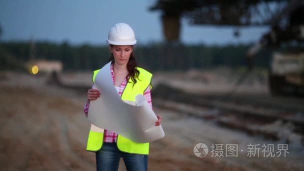 一名女工在职业堆垛机附近举行铁路计划
