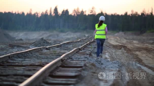 反光夹克女职工在铁路附近行驶视频