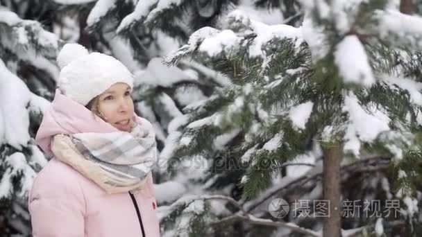 欧洲的美丽女孩喜欢冬季森林投掷用云杉慢动作雪