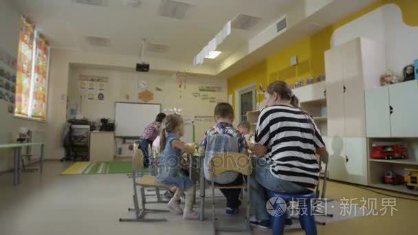 孩子们坐在幼儿园中的表视频