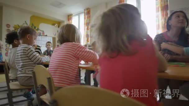孩子们坐在幼儿园中的表视频