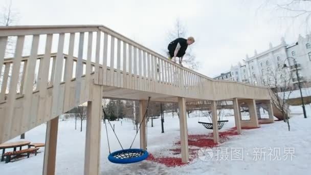 杂技的跑酷-免费的转轮跳在冬季雪公园，慢动作