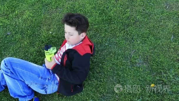 孩子躺在绿草喝水视频
