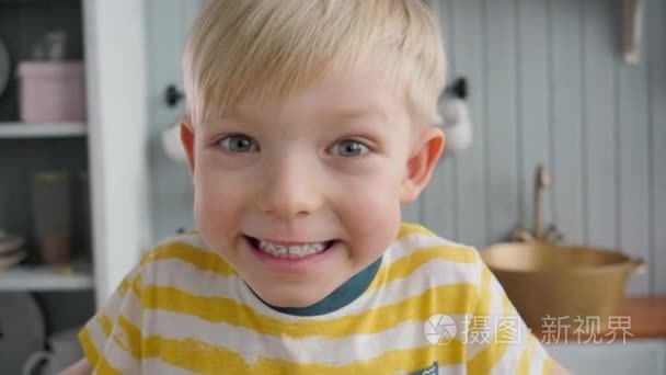 快乐的小儿童男孩在上午的现代厨房背景的肖像