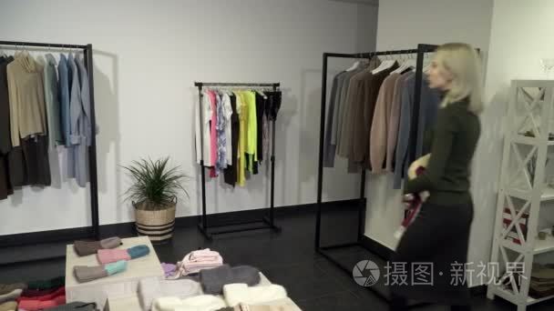 年轻的女人带回了衣服精品衣架视频