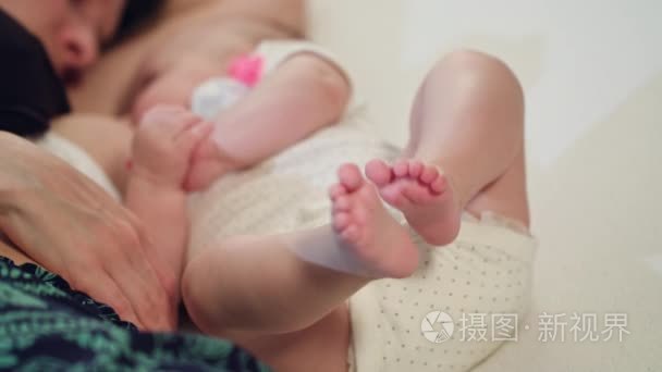 刚出生的婴儿哺乳的脚在焦点