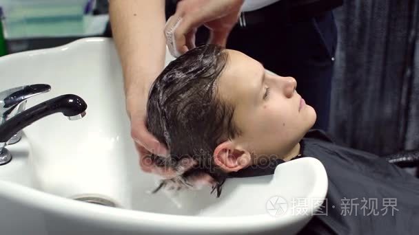 男理发师洗头发的男孩视频