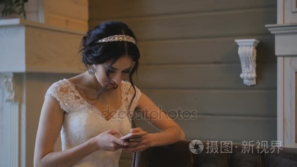 年轻的新娘在婚礼当天使用手机视频