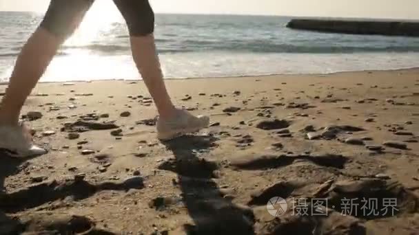 女子双腿穿着跑鞋跑步沿着海岸，海洋。运行在海边