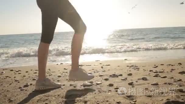 女子双腿穿着跑鞋跑步沿着海岸，海洋。运行在海边