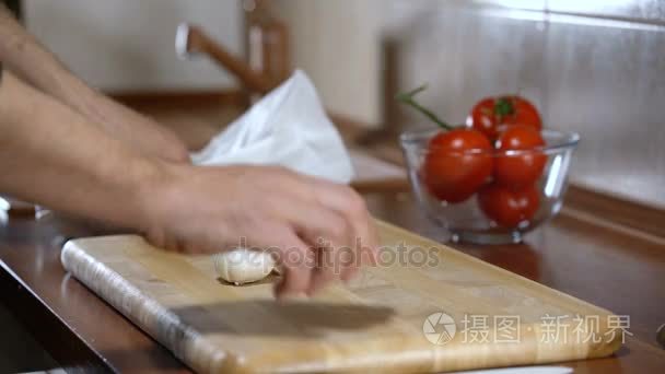 男人剥大蒜为烹饪意式烤面包视频