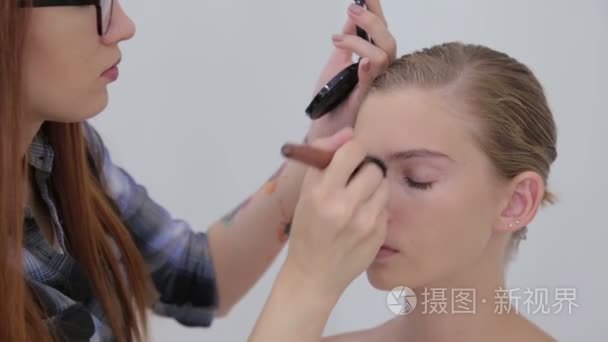 专业化妆师将粉应用于女孩的脸视频