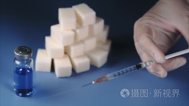 糖尿病的概念。安瓿瓶、 糖多维数据集和手中的胰岛素注射器