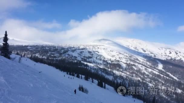 寒冬季节，雪山滑雪道伸展到天空和云 运动员 滑雪者和挡雪板落下。境般 1920 x 1080