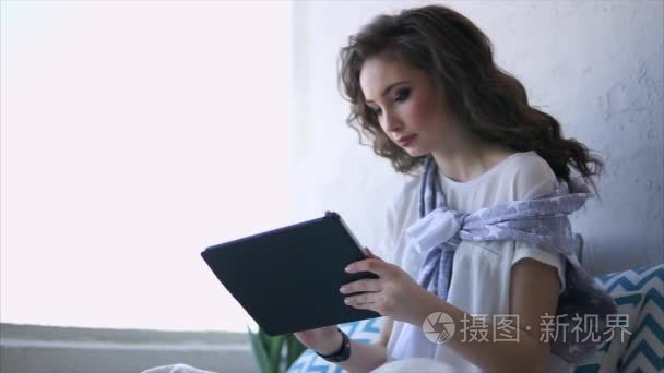 在互联网在平板电脑上在客厅里的漂亮的女人作品使用 wifi