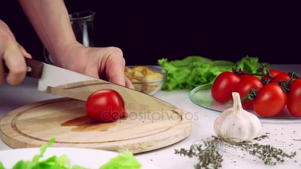 女人的手在厨房里的切片番茄