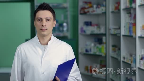 微笑男药师在药店里的白大衣视频