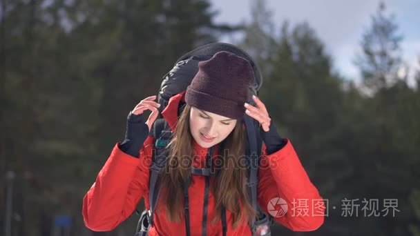 性格开朗，微笑的徒步旅行者摘下她的帽子。旅行者，在冬季森林徒步旅行者正面肖像。徒步旅行，爱，纯度，自由概念