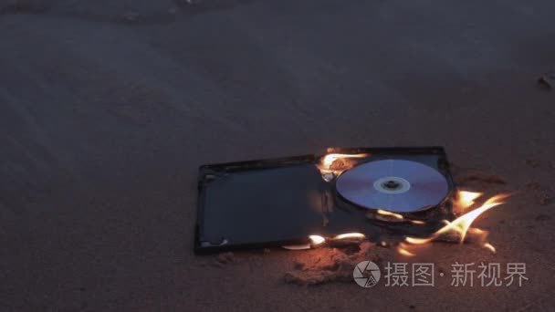 在海岸的沙子上燃烧数据盘视频