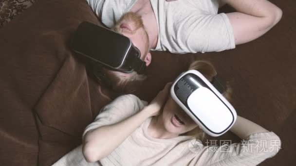 脸上的一个年轻的男人和一个女孩在虚拟现实眼镜的钦佩