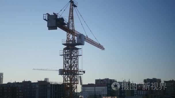 大型建筑起重机在房子和天空的背景上的城市。4 k，3840 × 2160