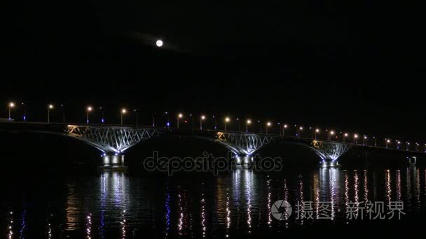 满月升起，这座桥。萨拉托夫的城市和恩格斯、 俄罗斯之间的道路桥梁。伏尔加河畔。傍晚的汽车和路灯的灯光。4 k，超高清