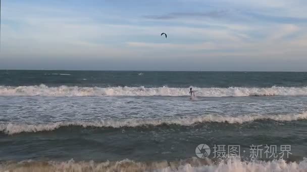 亚洲年轻男子跳进海浪海边