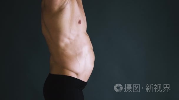 与完美 abs 显示新闻真空健体的六块腹肌的强健美。男人伪装在黑色的背景，显示他的新闻肌肉。健美，怎么摆，黑色