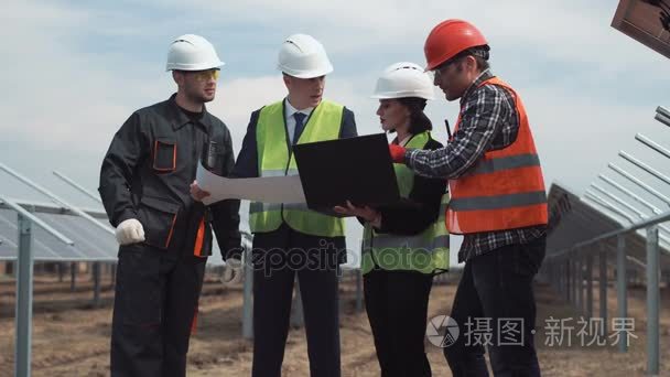 在太阳能农场蓝图的工程师工人