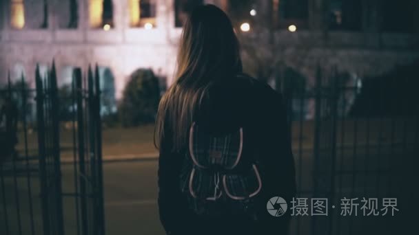 年轻的黑发女人来楼下对面在罗马，意大利罗马竞技场。小女孩在深夜走在这个城市