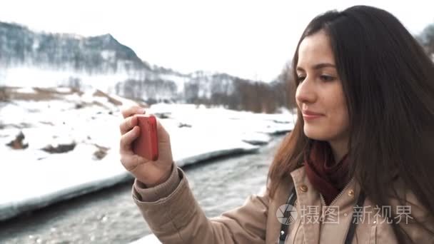 考虑自拍照背景的大山和绿色山区河流的白种人美女